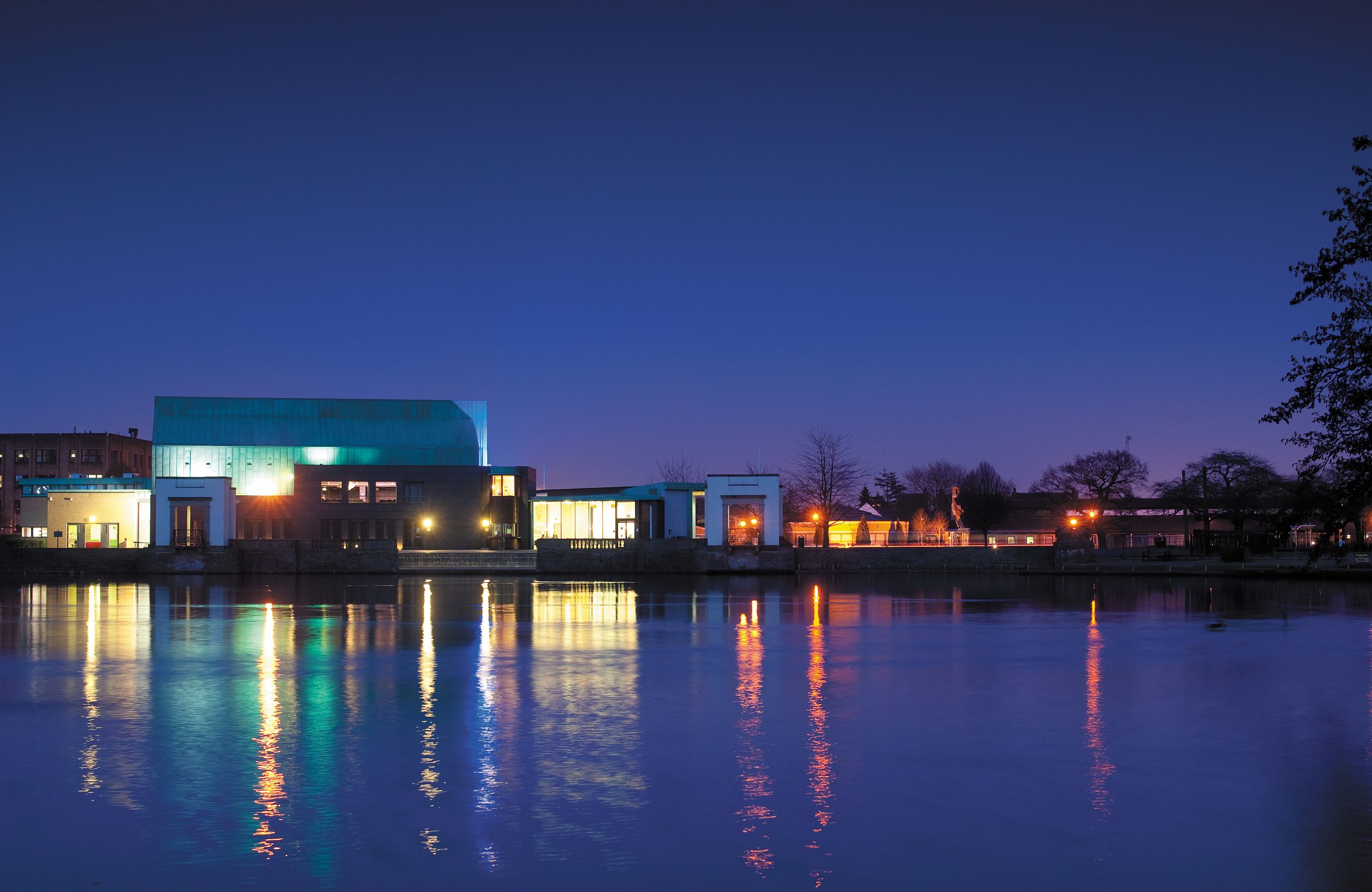 Lakeside Arts at night with bright lights reflecting in the water