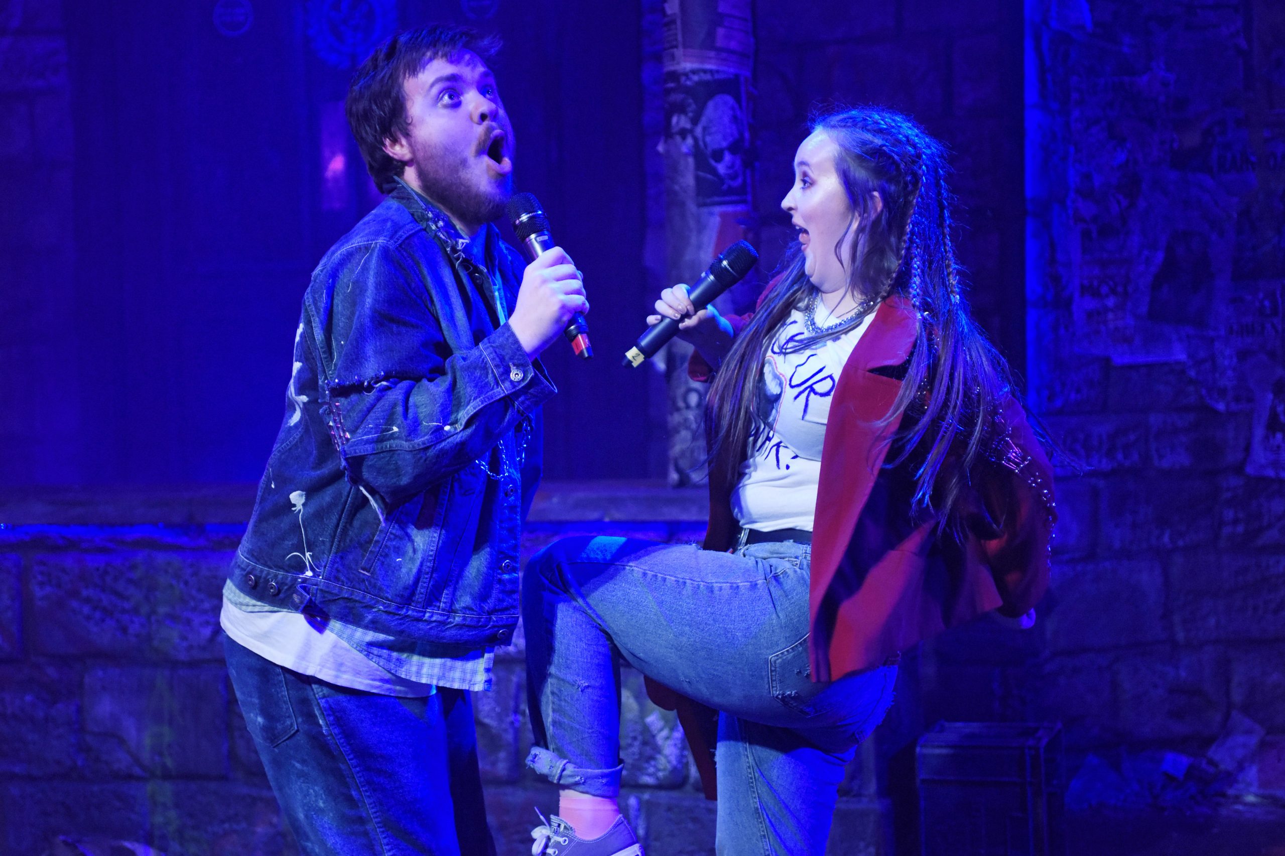 two actors sing together pulling silly faces