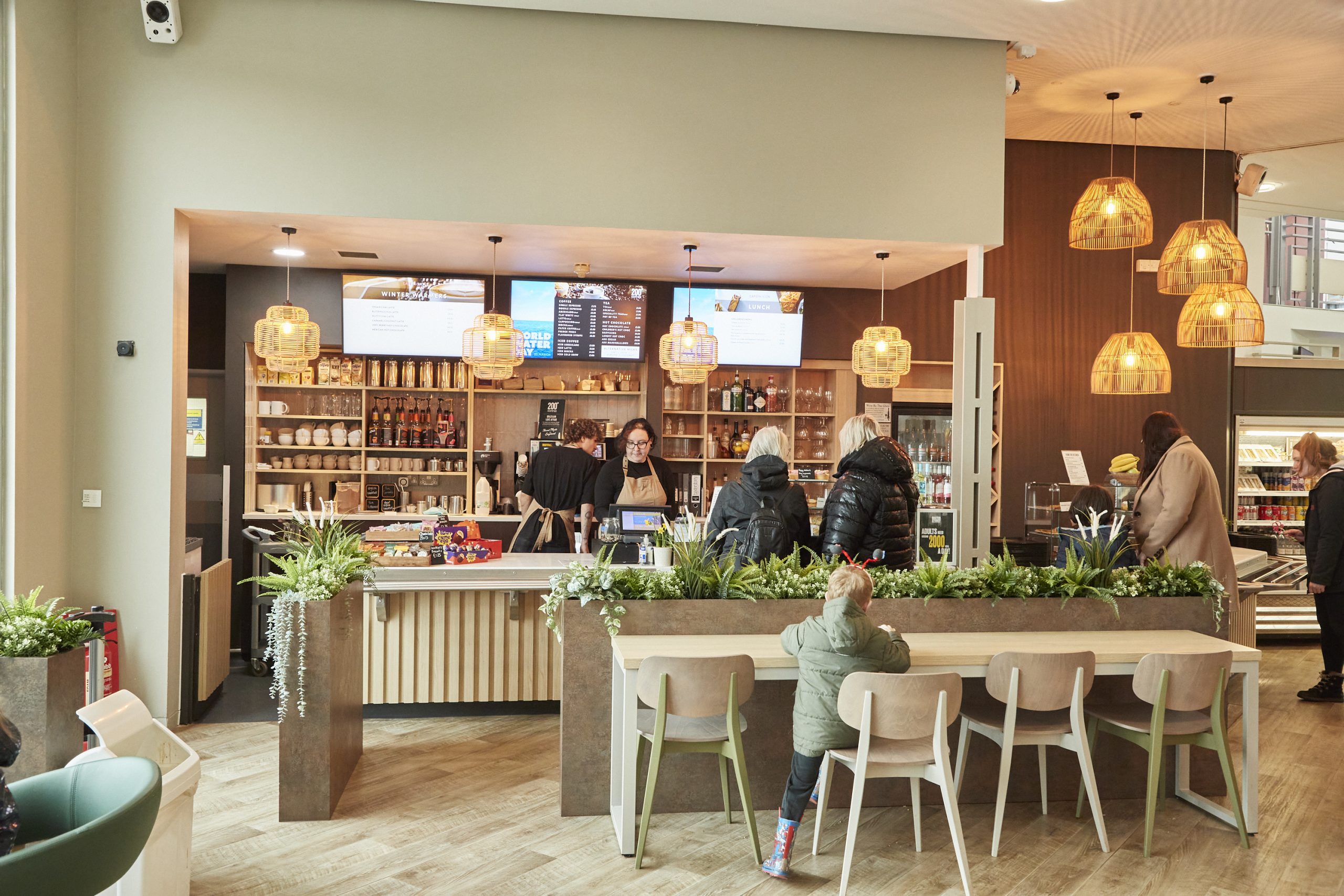 A busy café with warm lights and neutral coloured walls.